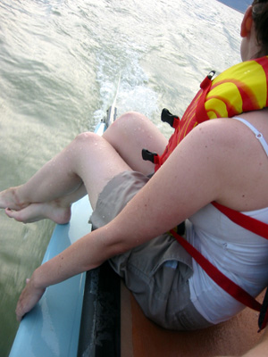 Amy drags her feet through the warm water